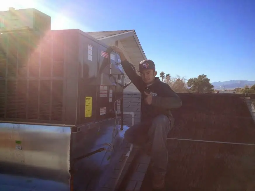 HVAC technician performing Air Duct Repair on a rooftop unit in Maywood